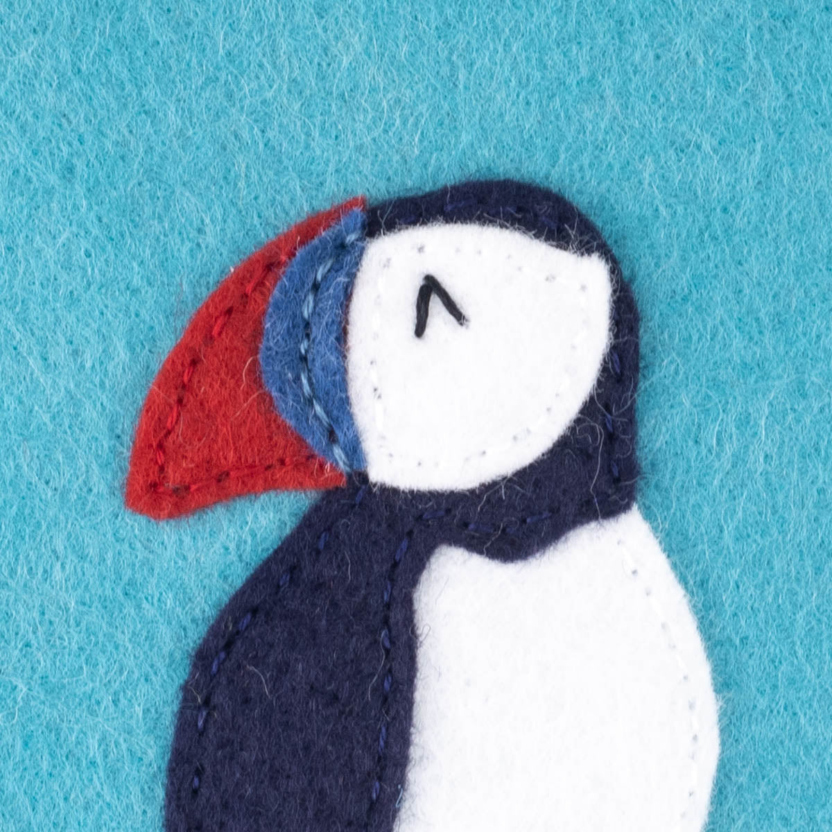Close up of the puffin's face showing how to begin stitching the eye